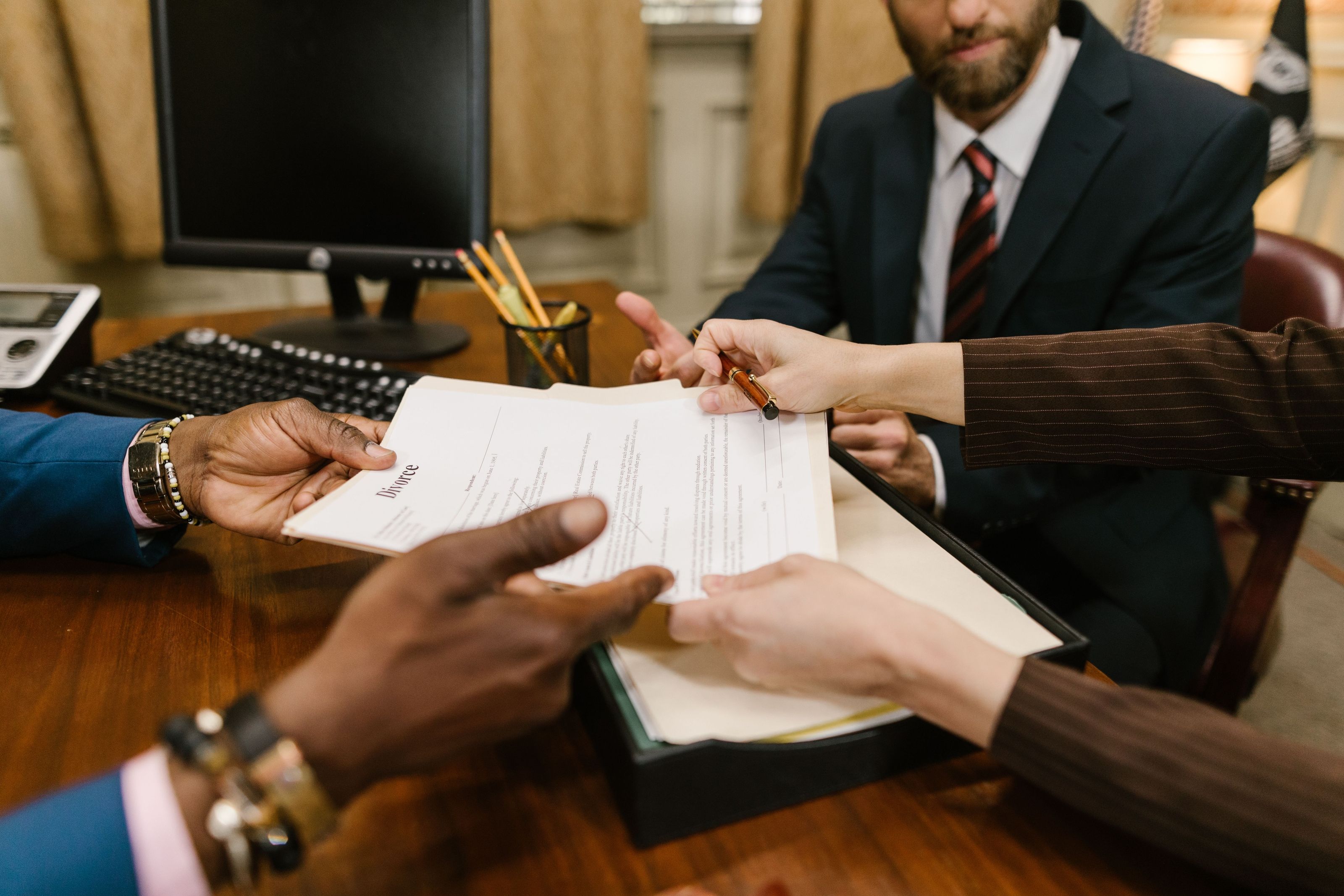 Mediator passing an agreement across the table to two participants