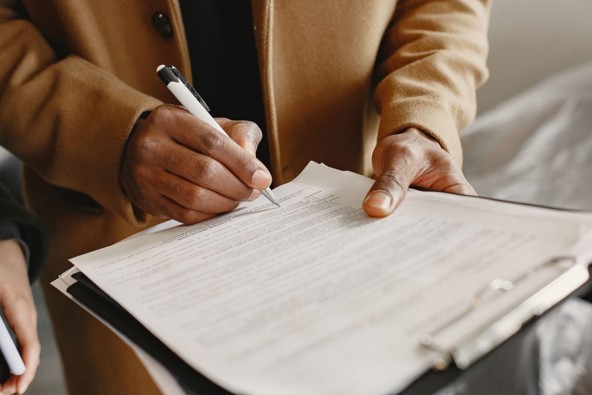 Couple signing an agreement together at an office desk