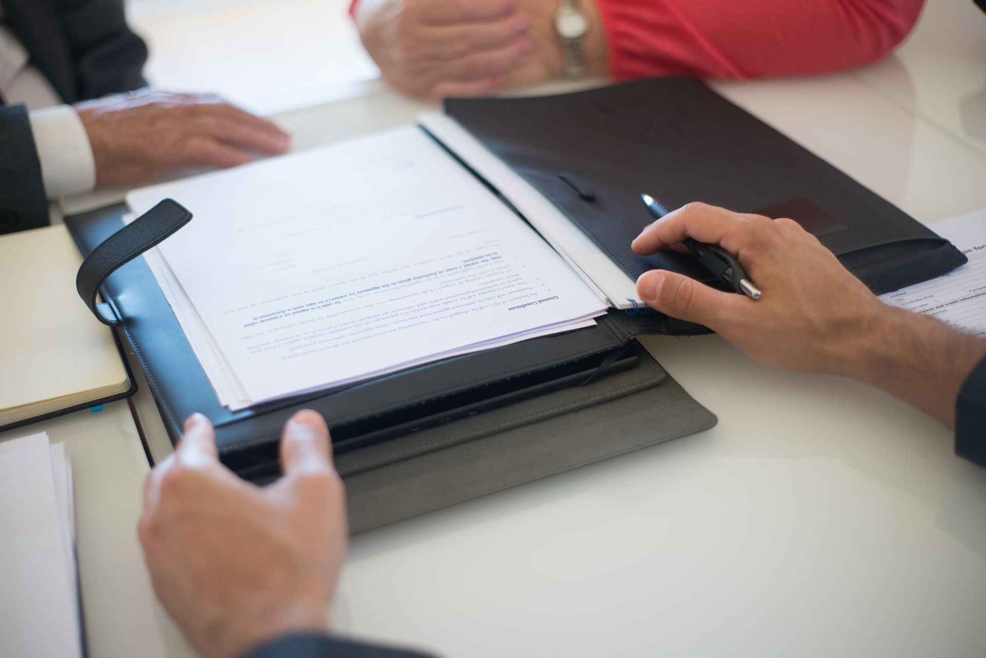 Attorney and client reviewing a folder of property documents