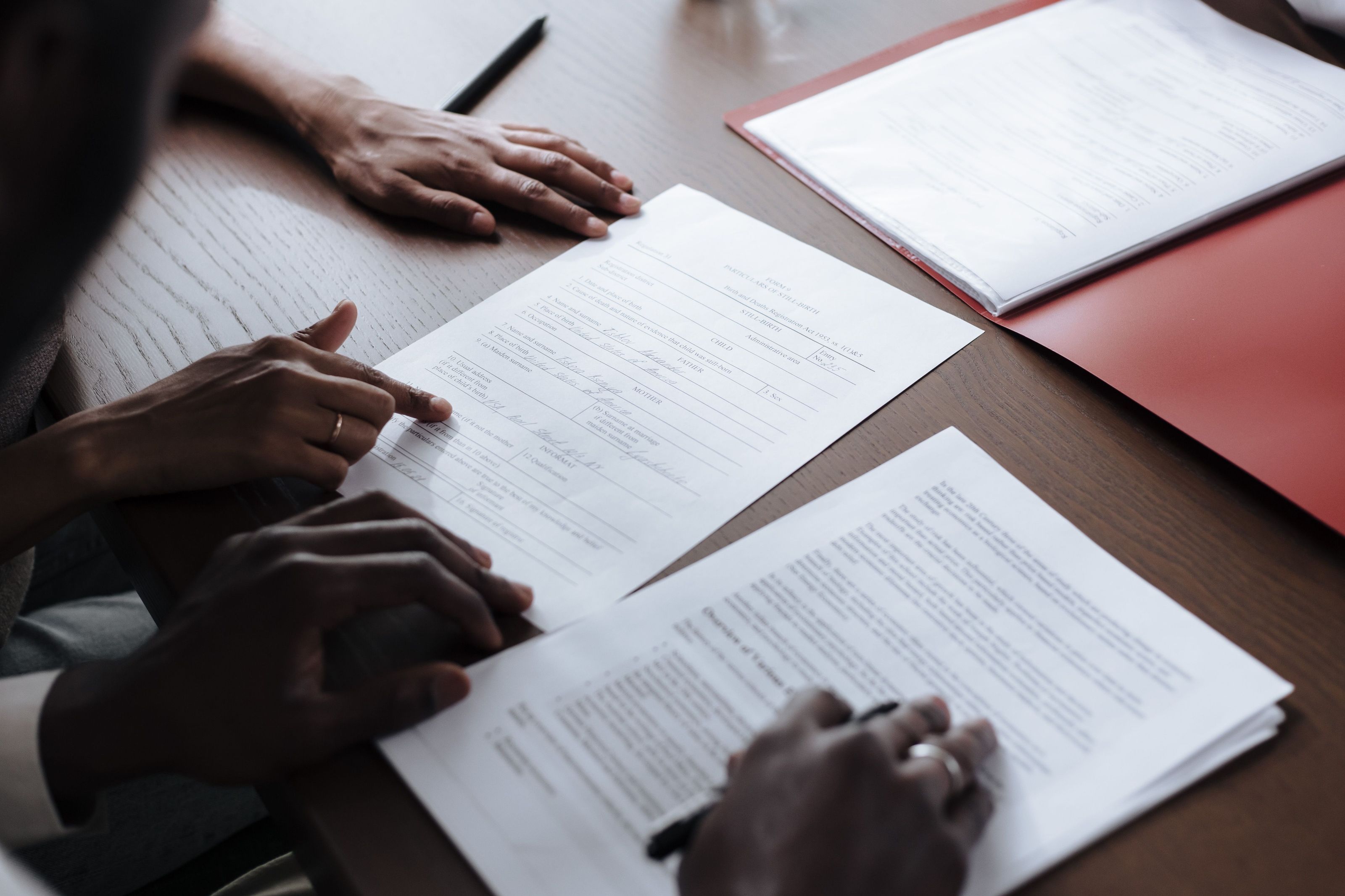 Two people reviewing settlement paperwork together across a desk