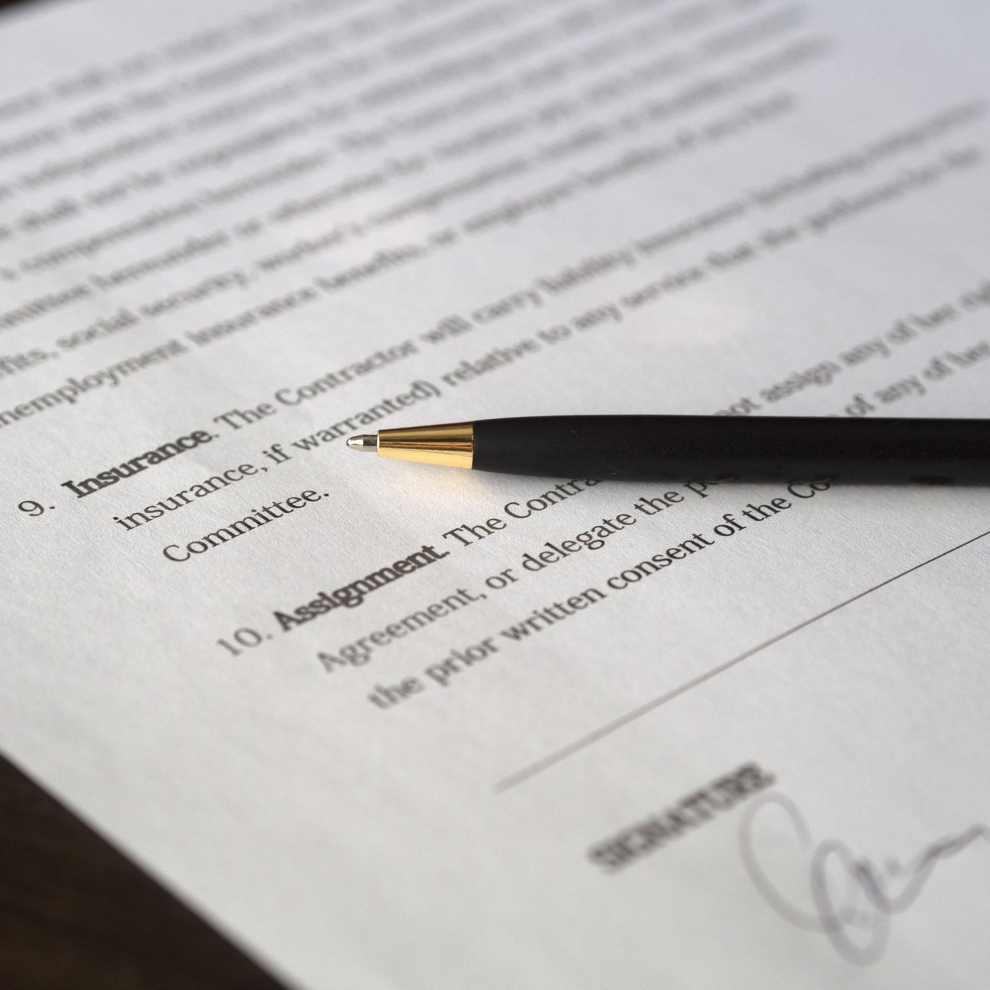 Pen poised over the signature line of a legal agreement
