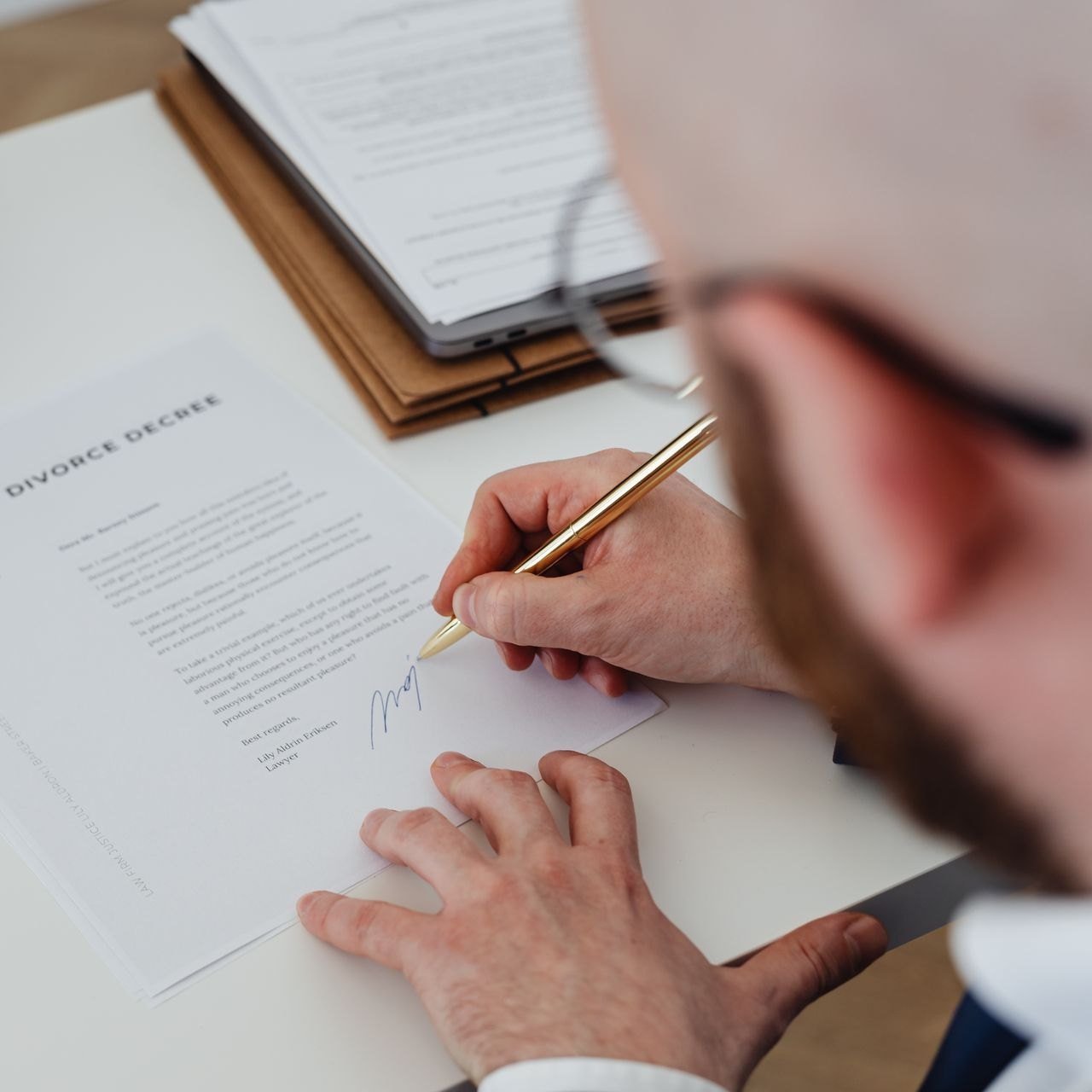 Signed divorce decree and a pen on a desk at an attorney meeting