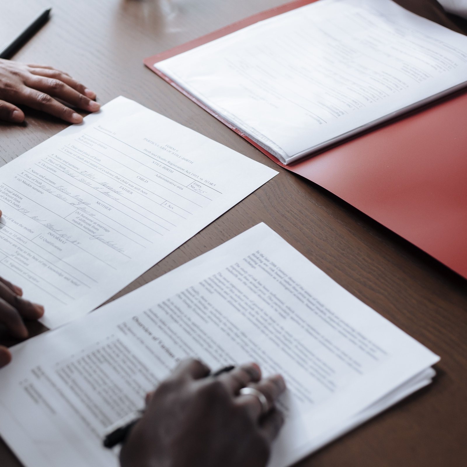 Settlement paperwork spread between two people at a desk